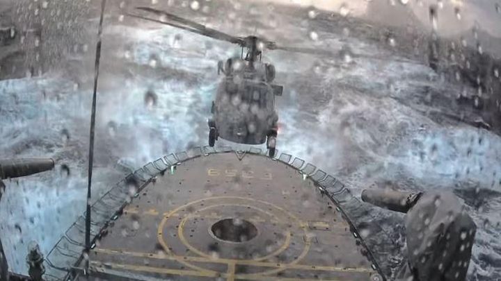 Посадка вертолета на палубу патрульного фрегата во время шторма Посадка вертолета на палубу патрульного фрегата во время шторма