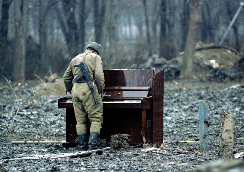 Русский солдат играет на пианино, оставленном в Чечне в 1994 году. вместо слов, фото
