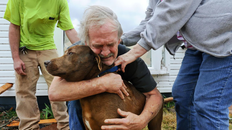 Грег Кук обнимает свою собаку Коко после того, как нашел ее в разрушенном торнадо доме в Алабаме. Март 2012 года. вместо слов, фото