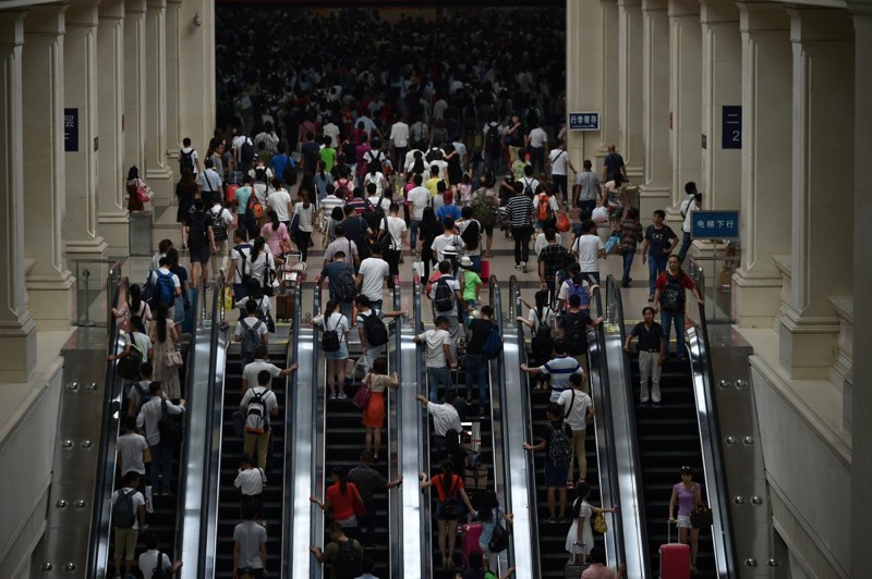 Пассажиры медленно пробираются к эскалаторам, чтобы спуститься на платформы. китай, люди, население
