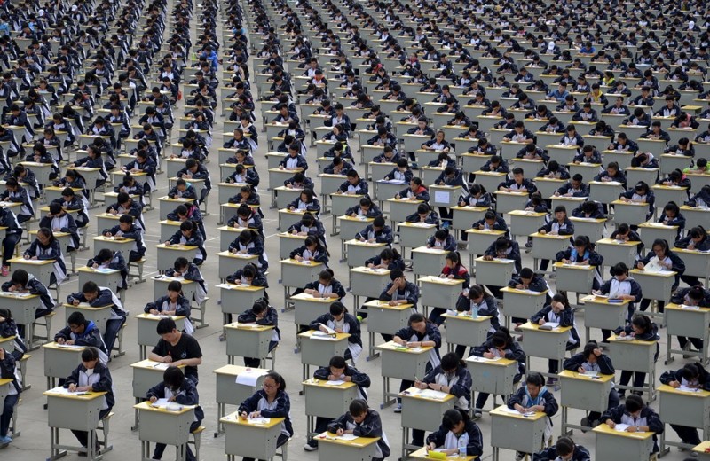 Ученики во время экзамена в старшей школе на школьной игровой площадке в Ичуане, провинция Шэньси. В 2015 году в экзамене участвовало более 1700 абитуриентов, и пришлось проводить его на улице, потому что в помещении было недостаточно места. китай, люди, население