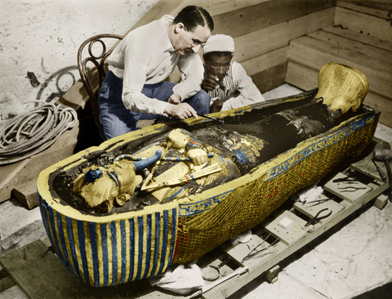 20. Археолог Говард Картер исследует золотой саркофаг Тутанхамона после открытия гробницы Тутанхамона в 1923 году. история, мир, фотография