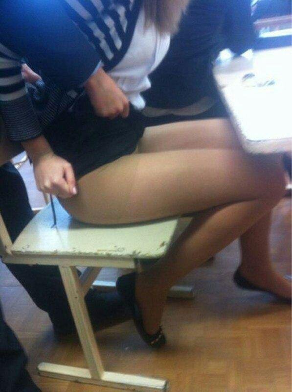 Девушка снимает под юбкой свою подругу пока они сидят за столом