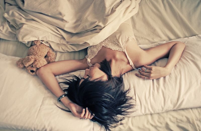Фото страстной девушки снимающей синий бюстгальтер лежа в постели