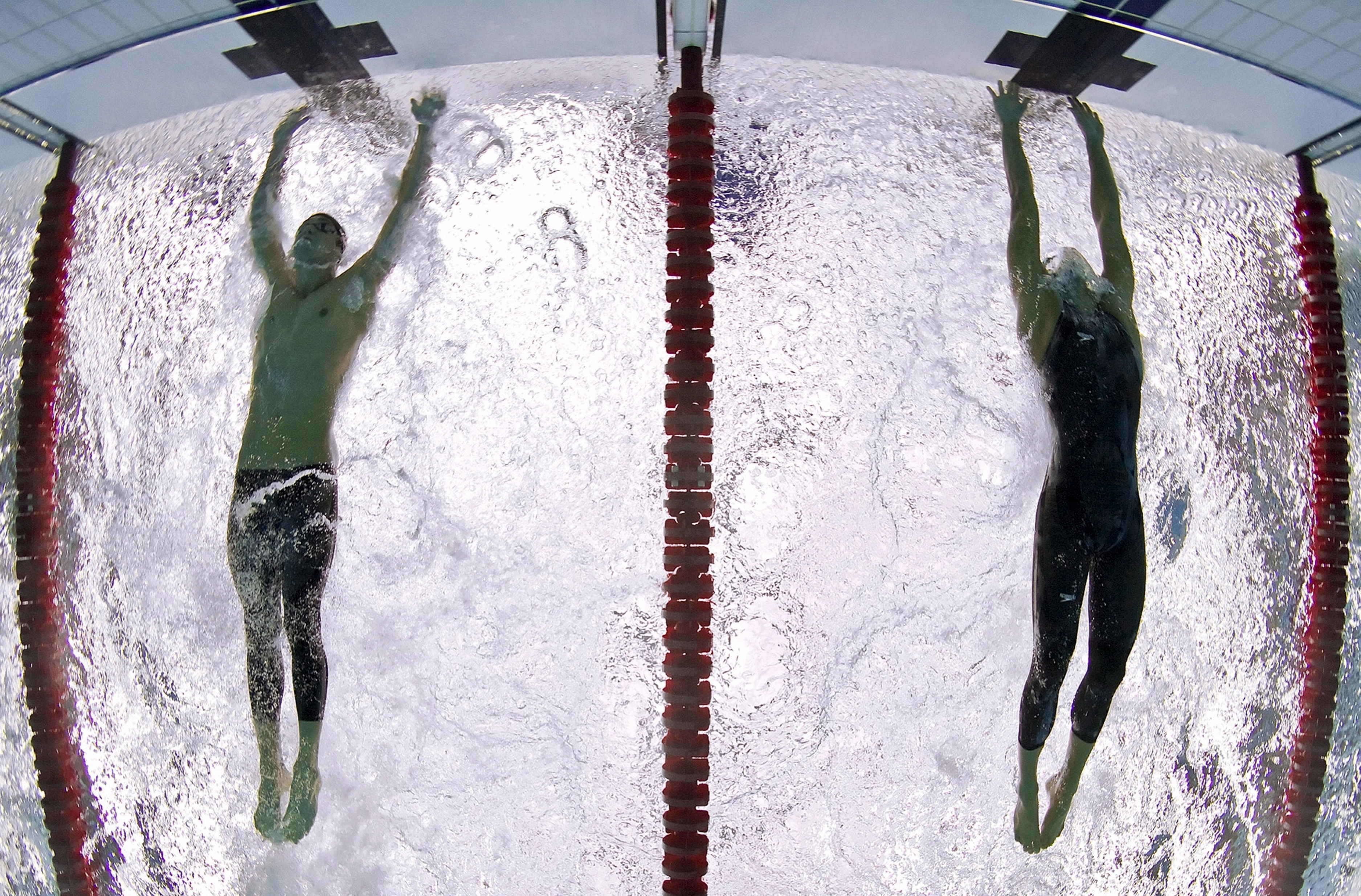 Американский пловец Майкл Фелпс опережает сербского пловца Милорада Чавича на 0,01 секунды на финише дистанции 100 метров баттерфляем.