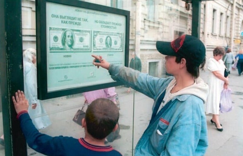 Дети рассматривают информационный постер о новом дизайне 100-долларовой банкноты. Москва 1996 год.