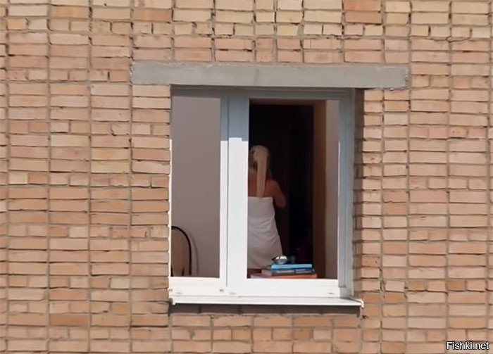 Парень с камерой в руках наблюдает за переодеванием девушки в окно
