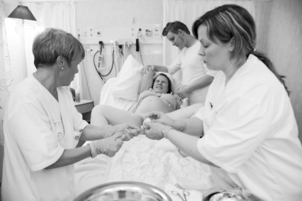 3 роды врачи. Женщина на родильном столе. Женщина в родильном зале. Процесс рождения ребенка в роддоме.