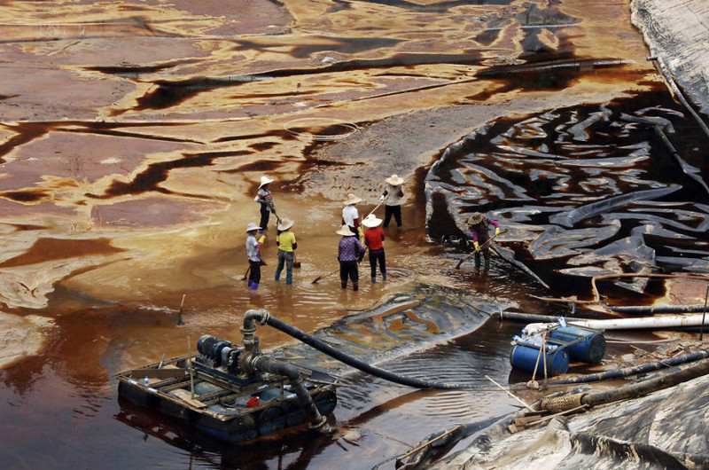 9. Рабочие пытаются вычерпать сточные воды после прорыва отстойника в провинции Фуцзянь