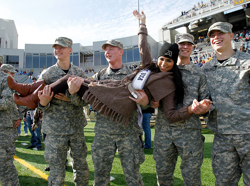 Мисс США-2010» Райма Факих позирует с американскими военнослужащими на футбольном матче