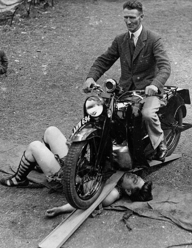 1 августа 1934 года. Самсон Браун, «сильнейший человек в мире», выдерживает мотоцикл, едущий по нему. 