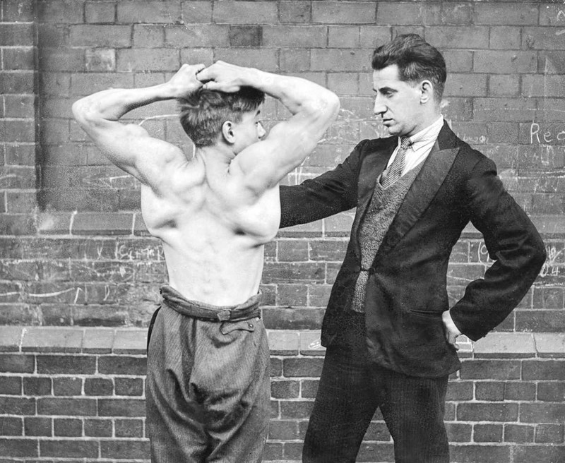 1 августа 1930 года. Льюис Кларк, «Сильный мальчик,» показывает мышцы спины.  