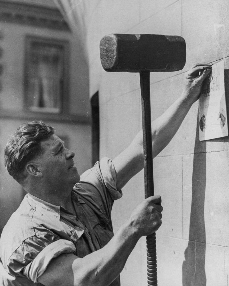14 августа 1934 года. Джо Прайс использует 23-килограммовый молоток, чтобы прибить объявление.  