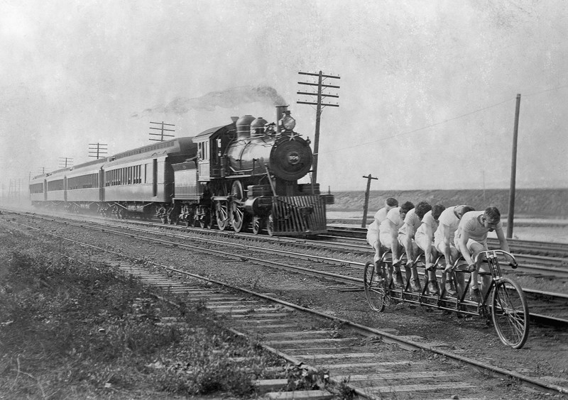 1896  год. Велосипедисты на шестиместном байке пытаются обогнать поезд.