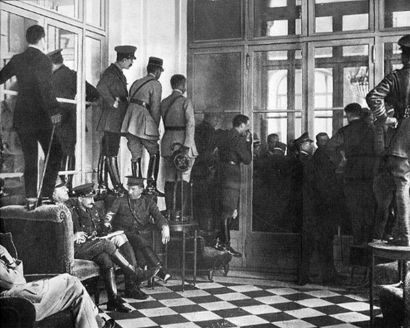 4. Люди стоят на кушетках, столах и стульях, чтобы увидеть подписание Версальского договора, официально завершившего Первую мировую войну, 1919 год.