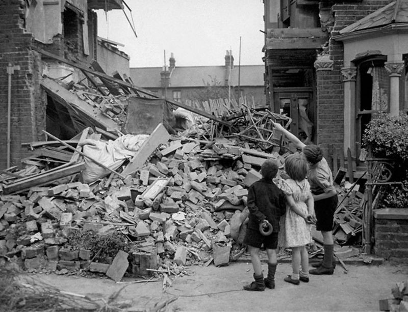 3. Бездомные дети в Лондоне после бомбежки немецкими силами 1940 г. Мальчик показывает, где раньше была его спальня.