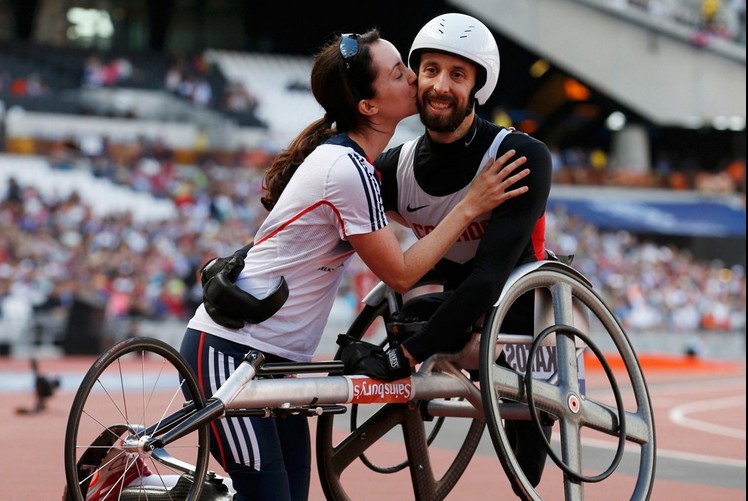 Канадец принимает поздравление от жены, после того как выиграл 100-метровку среди спортсменов на колясках на Паралимпийских играх 2012 в Лондоне 