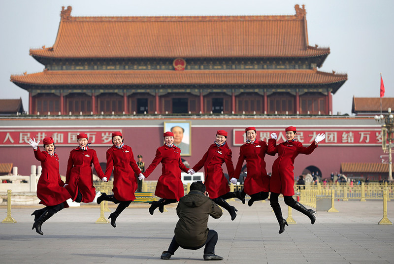 Команда девушек хостес, обслуживающих делегатов Всекитайского собрания народных представителей, позирует на площади Тяньаньмэнь, 12 марта.