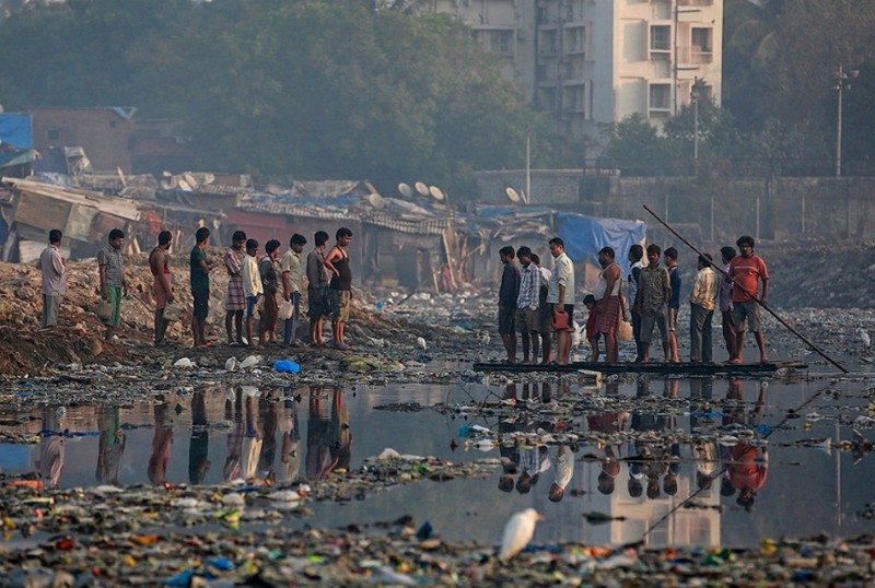 Мумбаиские трущобы. Этим людям приходится перебираться через горы мусора ради воды.