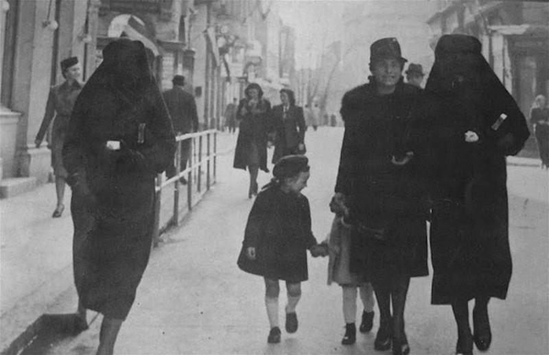 Мусульманка, прикрывающая своей чадрой желтую звезду своей соседки-еврейки на улицах Сараево(1941)