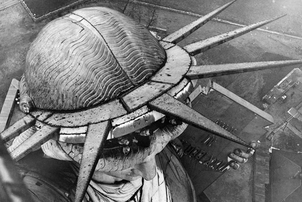 Туристы выглядывают из головы статуи Свободы в Нью-Йорке. США, 1930 год
