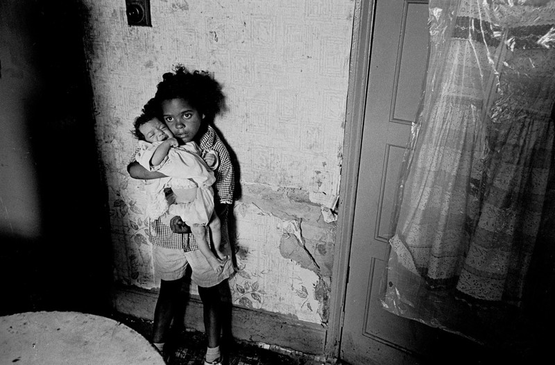 18. Бирмингем, 1970. Девочка со своей младшей сестрой в трущобах, где они жили.