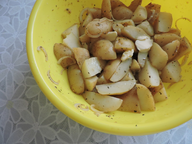 Через 30 минут достать курицу из маринада и положить картошку. Добавить кусочек масла и перемешать.