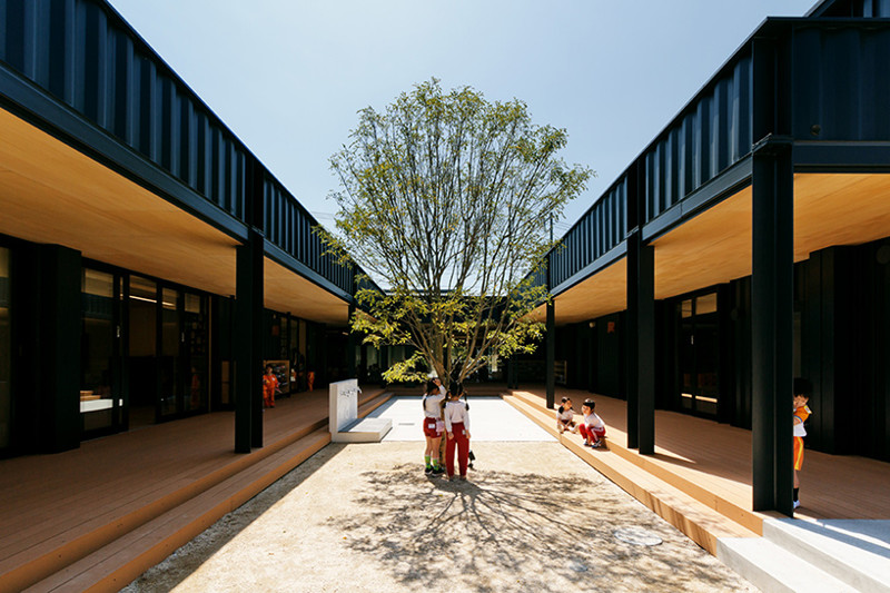 Команда архитекторов HIBINOSEKKEI + youji no shiro расположила детское дошкольное учреждение вокруг дворика, в котором растет всего одно дерево.  