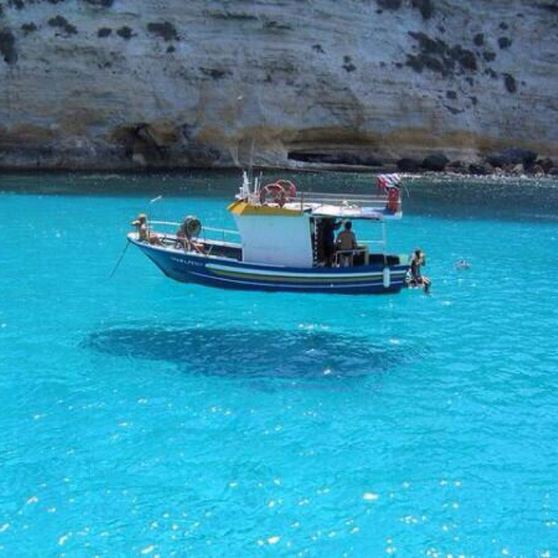 Вода настолько прозрачная, что кажется будто лодка просто парит в воздухе.