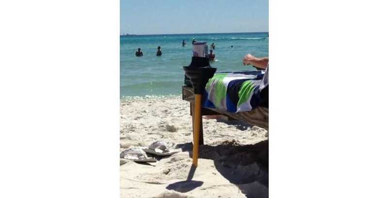 Вантуз, воткнутый в песок на пляже, превращается в подставку под банку с пивом