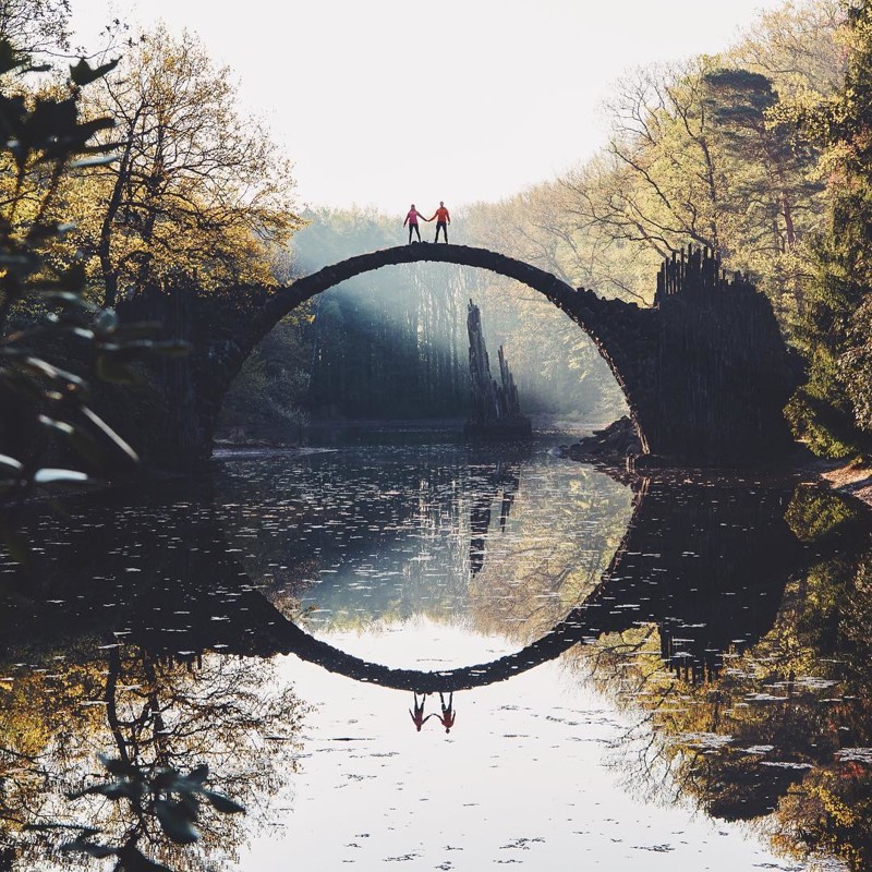 Здесь мост Ракотцбрюке (Чертов мост) в Германии выглядит появившимся прямо из сказки с туманным солнечным светом и парой, держащейся за руки.