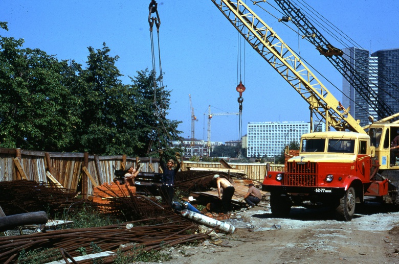 КрАЗ-автокран прибыл на новостройку. Сзади виднеется знаменитая «книжка» - здание СЭВ.