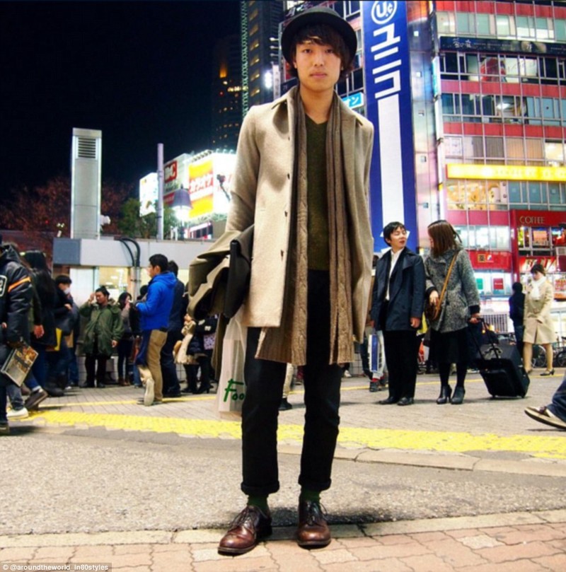 Студент Матумото Коусукэ позирует в Токио в ожидании друга