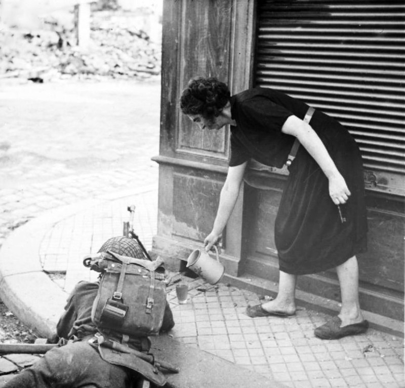 Французская женщина наливает чай канадскому солдату во время освобождения Лизьё. Нормандия. Франция. 22 августа 1944 года.