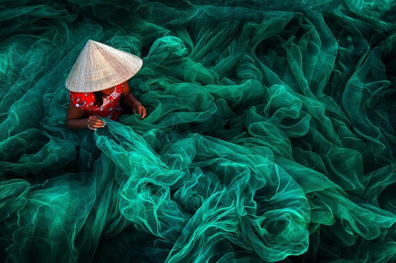 "Вьетнамская девушка плетёт рыболовную сеть" (1 место в номинации "Цвет",  автор Дэнни Йен Син Вонг)