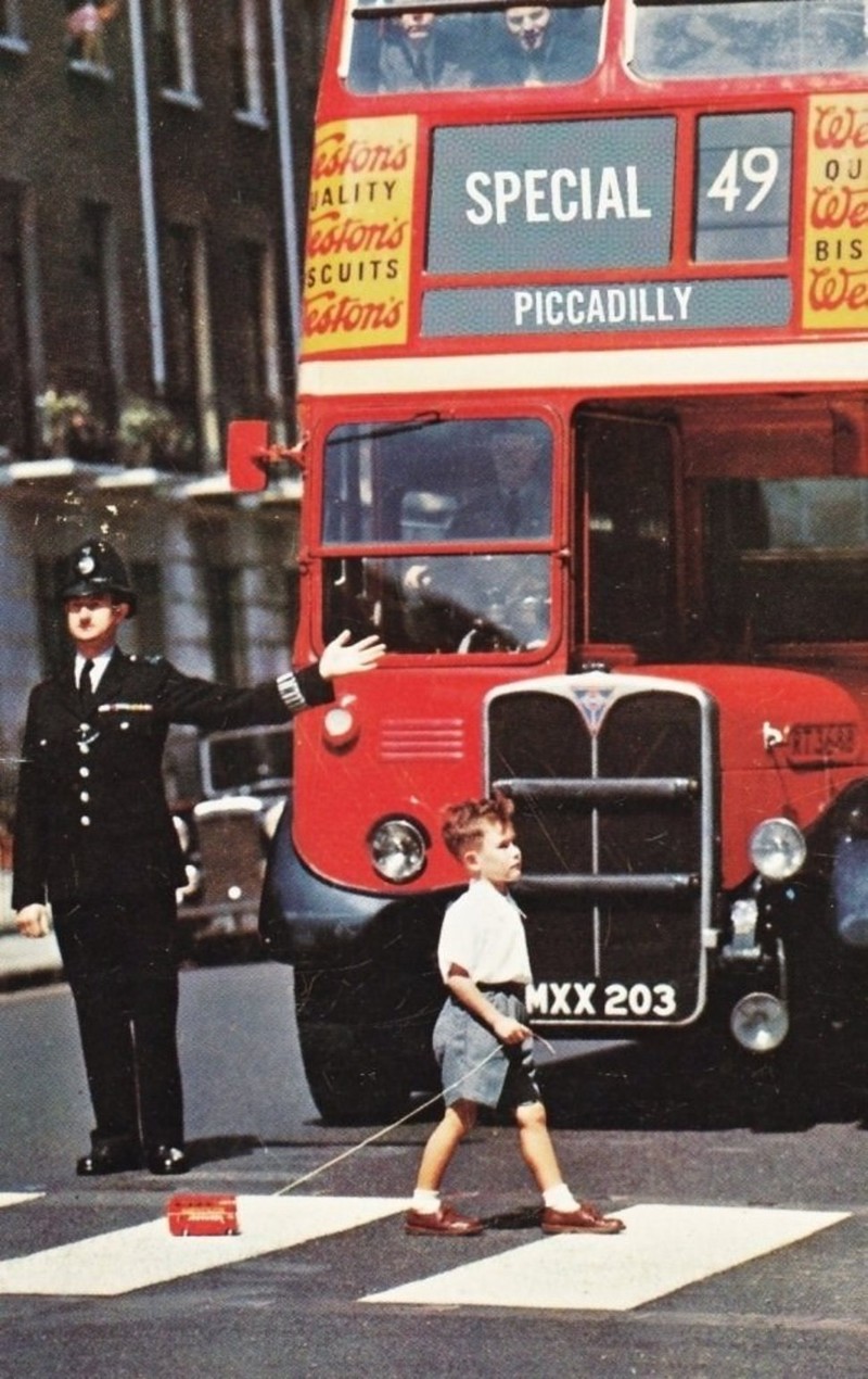 Мальчик переходит улицу, везя на веревочке игрушечный двухэтажный автобус (Лондон, 1960-е гг.)