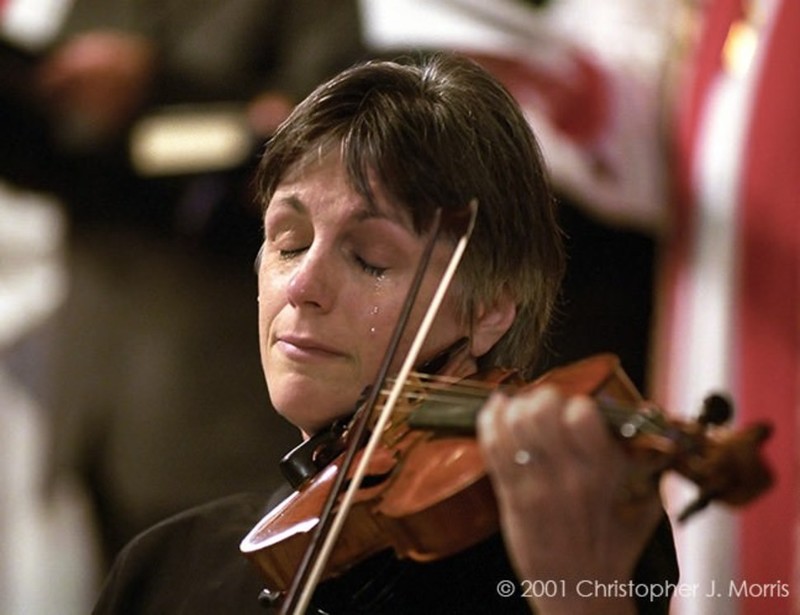 Скрипачка плачет во время поминальной службы в Christ Church Cathedral в Ванкувере в память о жертвах 11 сентября