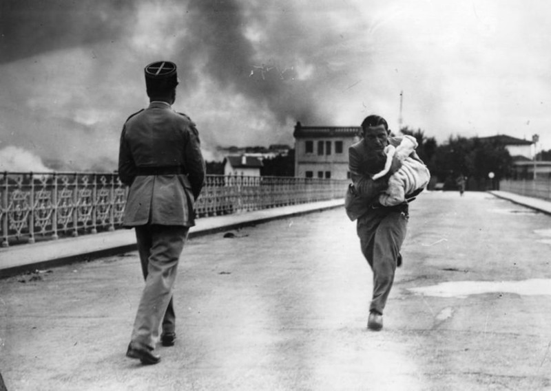 Журналист Реймонд Уокер бежит по мосту во Францию с ребенком, которого он спас от испанской гражданской войны (1936 г.)