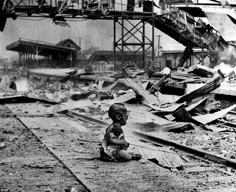 Окровавленный ребенок плачет на руинах железнодорожного вокзала Шанхая после японской бомбардировки 28 августа 1937 года (во время китайско-японской войны).