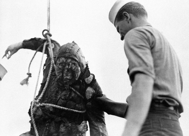 Американский моряк смотрит на обгоревший труп японского пилота, который достали со дна Перл-Харбор