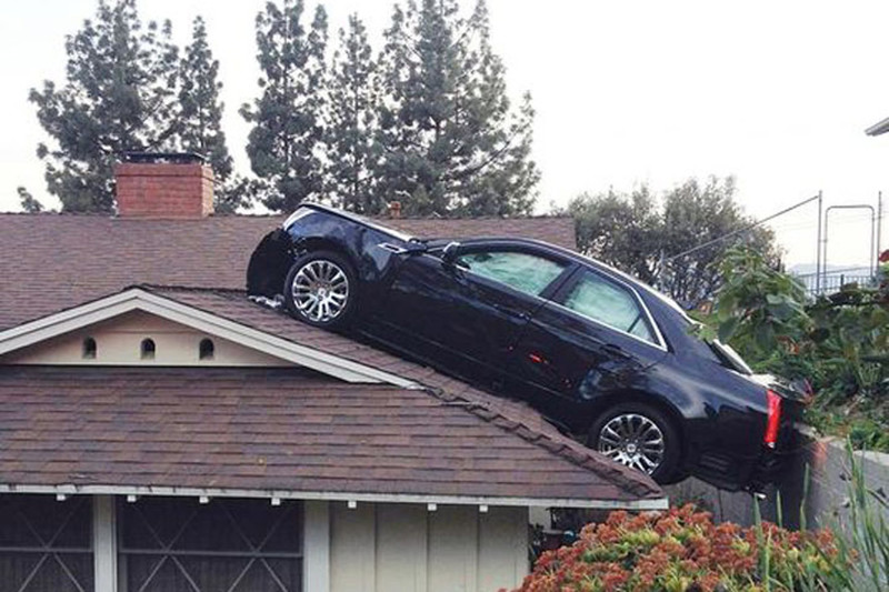 10. Водитель автомобиля Cadillac из-за неисправности случайно заехал на крышу соседского дома, который располагается на склоне. Просто в своем дворе места на стоянке не было!