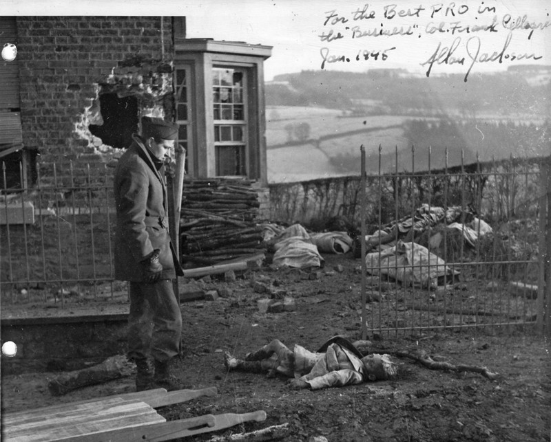 64. Американский солдат возле тел убитых немцами мирных жителей. Ставело, Бельгия, январь 1945-го года