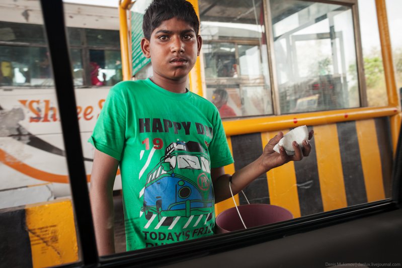 Мальчик продает кокосовые дольки на пункте оплаты за проезд по автомагистрали. Помимо мальчиков-продавцов на этих пунктах толпами ходят обычные попрошайки.