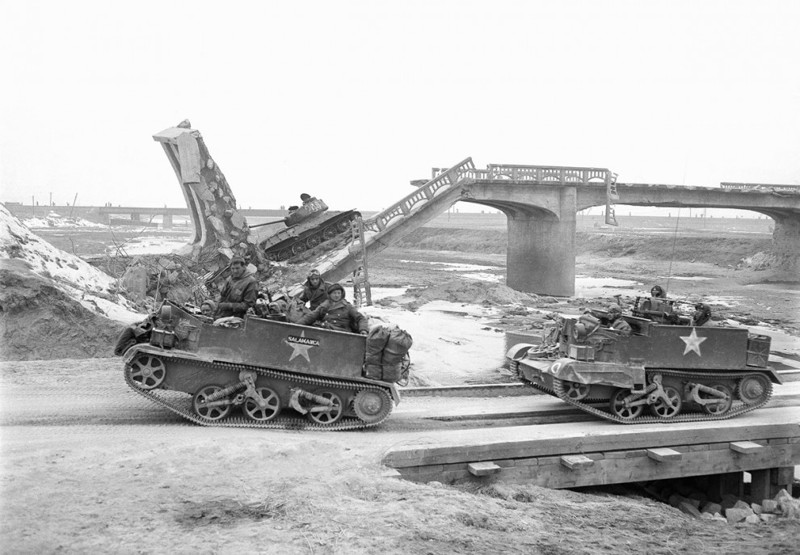 Британские бронетранспортёры проезжают мимо разбитого советского танка Т-34 на мосту возле Осана, Южная Корея, 6 января 1950 года. 