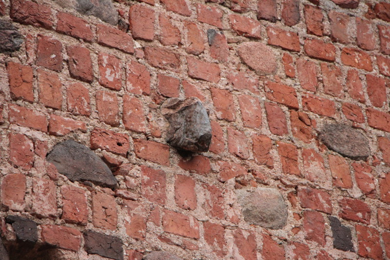 Камень в стене замка в виде головы зубра 