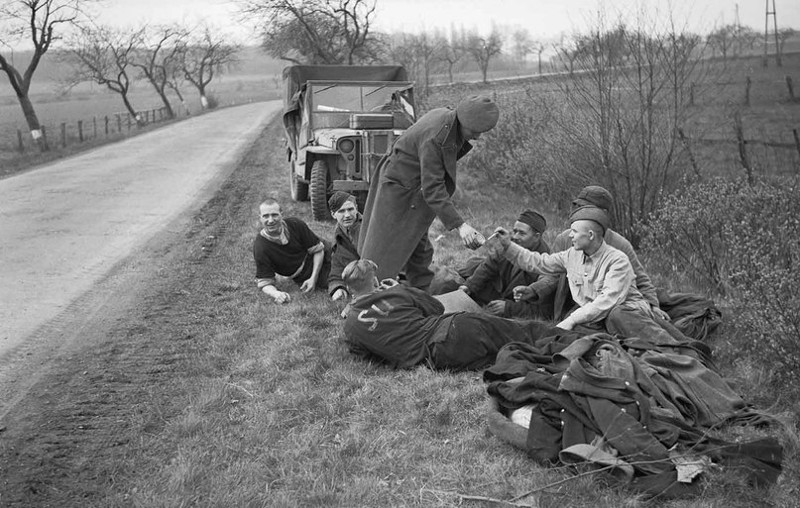 Британский солдат угощает сигаретами освобожденных советских военнопленных на дороге к северу от Ганновера, 1945 год.