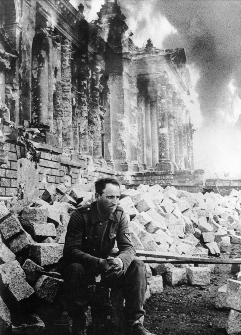 Немецкий солдат сидит перед горящим Рейхстагом