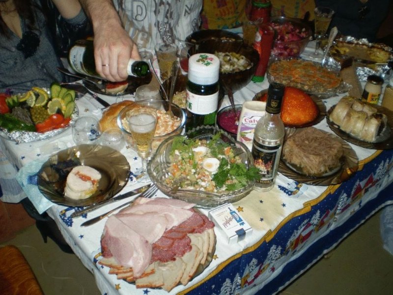  В реальности всё выглядело ближе к вот такому. Фото сделано уже в постсоветские годы, но само меню чисто советское — шампанское, водка, холодец, салат из свеклы (с чесноком и майонезом), оливье, крабовый салат с кукурузой, винегрет.