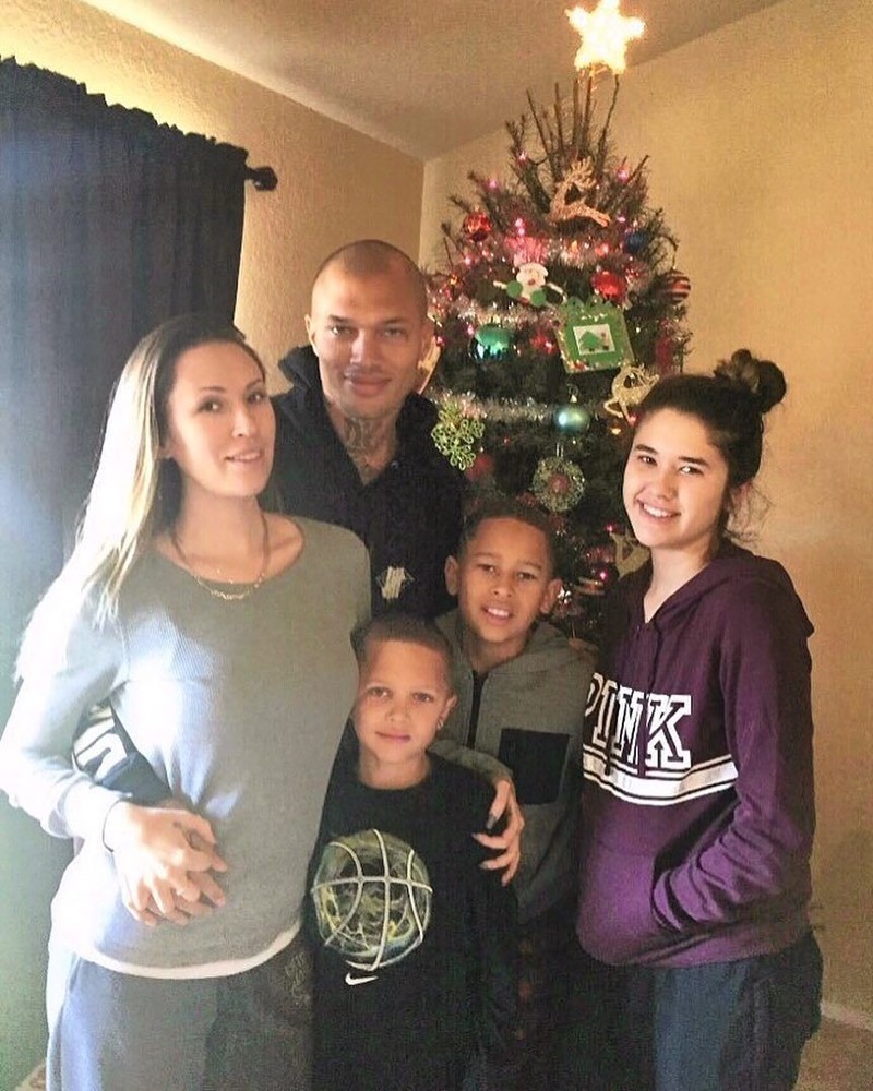 Еще один снимок показывает пару с тремя детьми возле рождественской елки.   