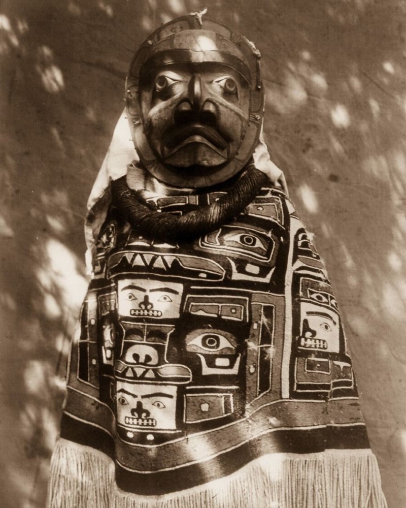 Женщина в пончо и маске, олицетворяющей умершего родственника, который был шаманом, 1914